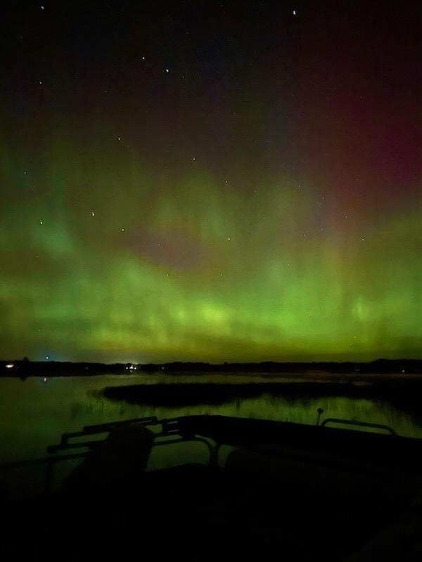 Northern lights over the bay behind one of the cabins.