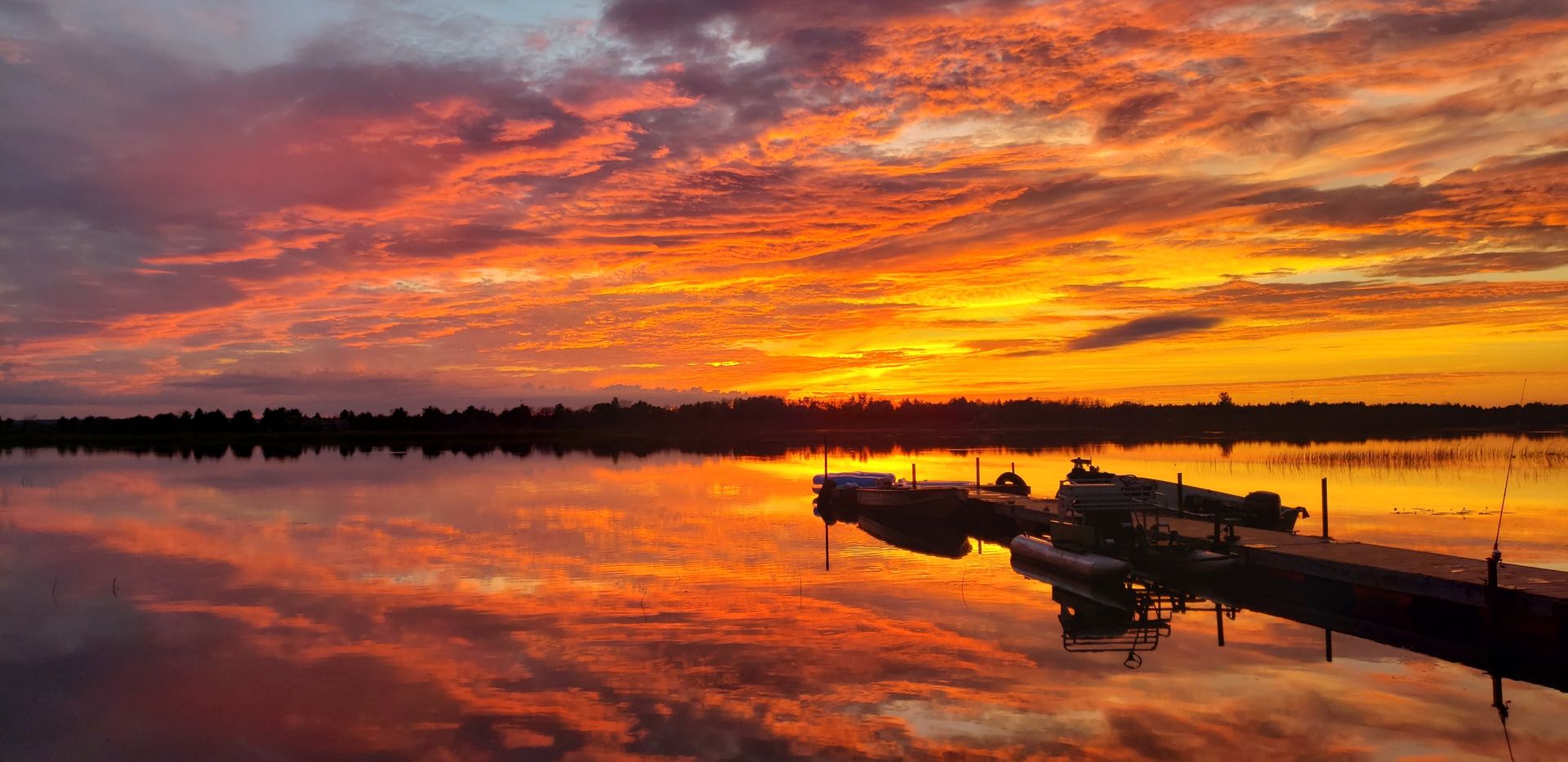A fiery sunset over Little Bay De Noc, with boats resting at our dock in the foreground.