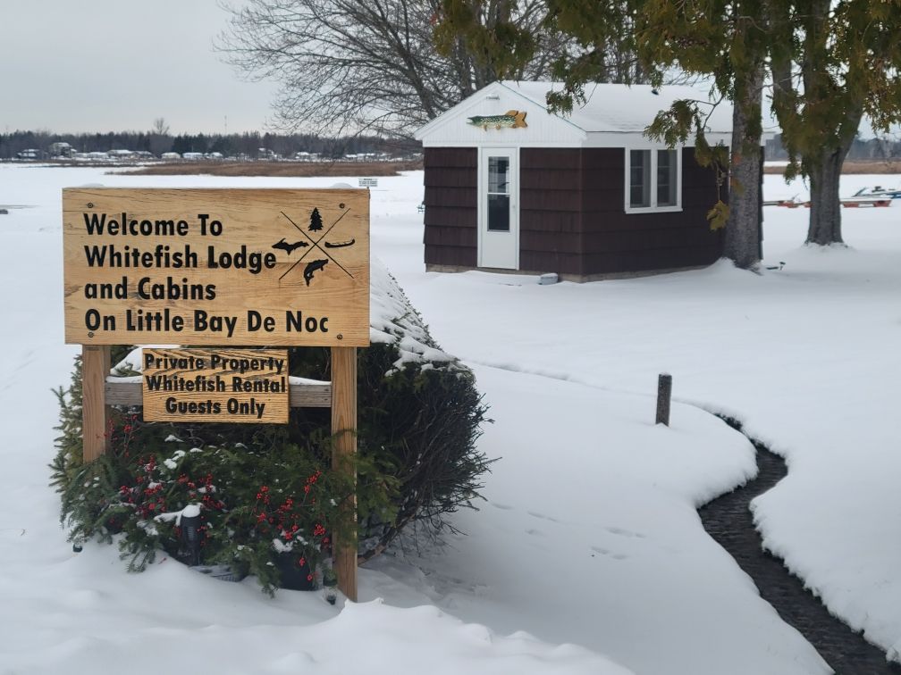 The same carved welcome sign standing in fresh snow.